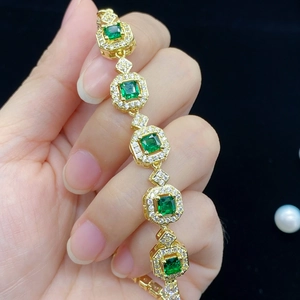 Elegant gold bracelet featuring square green tourmaline stones and sparkling diamonds