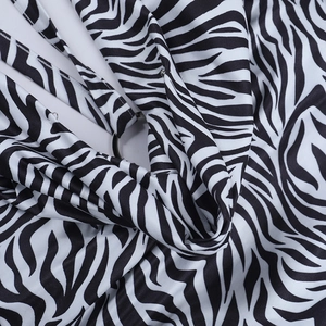 Détail macro du tissu à imprimé zèbre avec anneau métallique et texture soyeuse