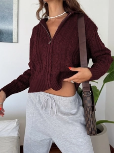 Detail of burgundy cable knit zip-up sweater showing texture and casual styling on model