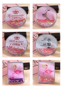 Close-up of portable quicksand mirrors with pink glitter hearts and flamingo patterns