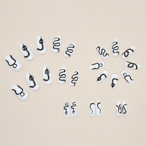 Almond shaped press-on nails featuring minimalist black snake wave patterns on white base