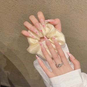 Aurora ballerina press-on nails with red bows and pearl French tips on almond shape
