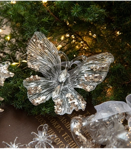 Macro di un ciondolo a farfalla in acrilico trasparente con paillettes oro per Natale