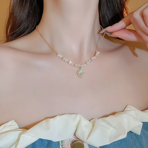 Détail d'un collier de style français vintage avec perles baroques et pendentif en strass
