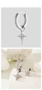 Detailed view of silver star earrings set with zircon stones and polished steel finish