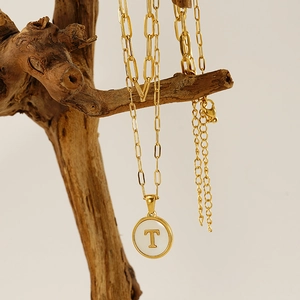 Collier double épaisseur en acier inoxydable doré avec pendentif lettre T sur bois