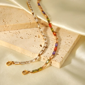 Detail of 18K gold stainless steel bracelets with baguette cut zircons on silk background