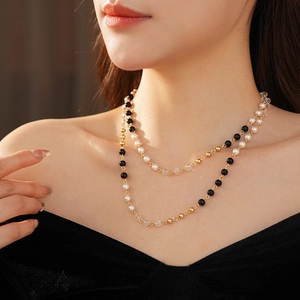 Gros plan du collier double rang en chaîne dorée avec perles et cristaux sur mannequin