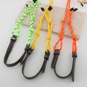 Macro detail of braided dopamine-style eyeglass chains in neon green, yellow and orange