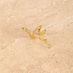 Macro shot of gold snake ear cuff featuring intricate scale textures and curved metal design