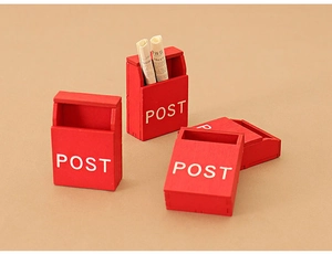 Detailed view of red wooden miniature dollhouse postboxes with tiny newspapers