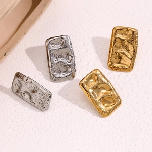 Detailed macro view of rectangular hammered metal studs in gold and silver finishes