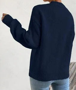 Close-up of navy blue loose-knit sweater showing chunky rib texture and drop shoulder detail