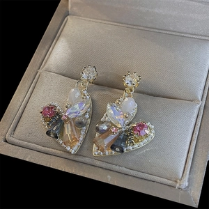 Detail of heart-shaped crystal drop earrings with beaded trim and multicolor stones