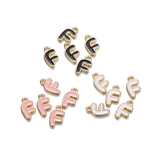 Detailed view of alloy letter F enamel pendants for DIY jewelry in black, pink, and white