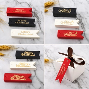 Dettaglio di eleganti etichette regalo natalizie in cartoncino con stampa oro a caldo