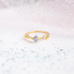 Macro detail of planet ring with blue stone, gold saturn ring and sparkling star accents