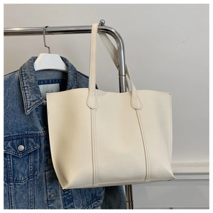 Détail du grand sac cabas crème avec coutures raffinées présenté dans un cadre de vie