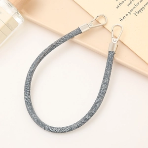 Close-up of a grey woven PU leather hand strap with silver metal buckles on a display tray