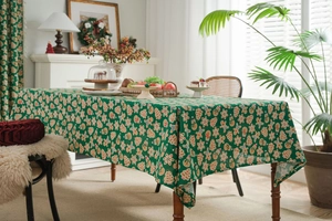Detailed texture of green linen tablecloth featuring gingerbread man and snowflake patterns