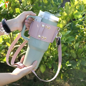 Green tumbler with pink leather carrier sleeve including card slots and adjustable strap
