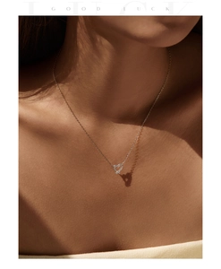 Macro view of gold-plated heart necklace with pavé stones and romantic heart shadow