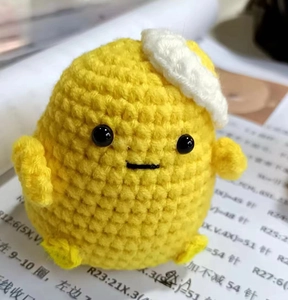 Close-up of handmade yellow crochet duckling doll with detailed knitting patterns