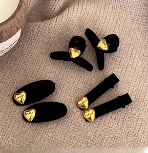 Dettaglio di fermagli per capelli neri floccati con decorazioni a cuore HAMMER dorati