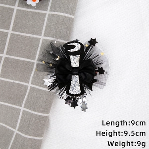 Detail shot of black graduation bow hair clip with mesh veil, stars, and moon sequins