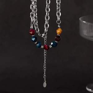 Detail of chunky stainless steel chain necklace with colorful geometric stone beads