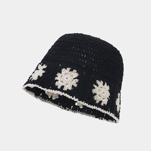 Detail of hand-crocheted hollow floral pattern on a black and white bucket hat