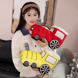 Plush train toys in red and yellow colors held by a model in a cozy home setting