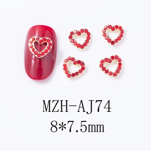 Détails macro de bijoux d'ongles en forme de cœur rouge évidé avec base dorée