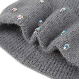 Détail de strass colorés sur un tissu en maille grise épaisse pour bonnet femme