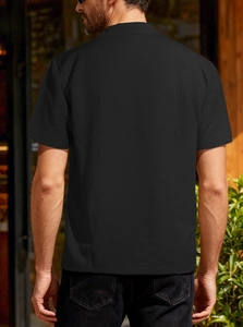 Vue arrière détaillée d'un polo noir en maille pour homme avec tissu texturé premium