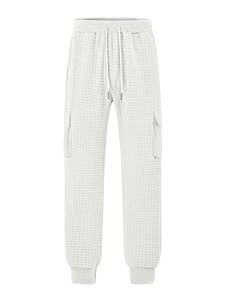 Detailed view of grey quilted jogger pants with cargo pockets and drawstring waist
