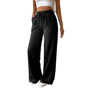 Women's loose black corduroy wide leg pants with drawstring waist on white background