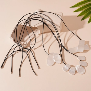 Minimalist silver geometric pendant necklaces with adjustable black cord on stone decor