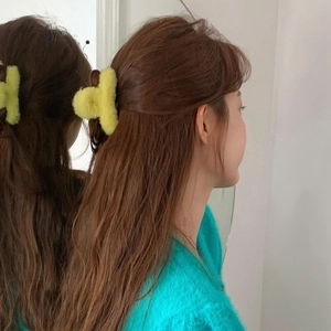 Hellgelbe Plüsch Haarklammer am Modell Haar durch Spiegelreflexion gesehen