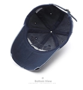 Detail of navy cotton baseball cap showing internal washing label and metal buckle strap