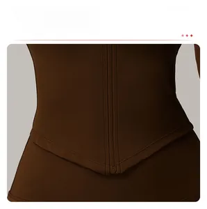 Vue détaillée du haut de sport marron foncé avec fermeture éclair et coupe ajustée avec ourlet en V