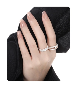 Detailed view of silver rings with bark texture and amber stone on black silk