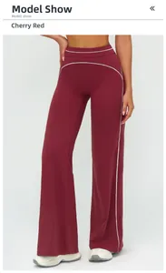 Detail view of cherry red high-waisted yoga pants with white side stripe and slim fit