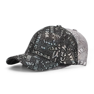 Detail of hard-top baseball cap featuring silver foil graffiti print and grey stitching