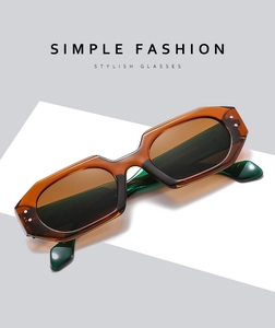 Chic polygonal amber sunglasses with dark green lenses on a minimal grey background