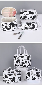 Detail of cow print makeup bag set showing portable storage organizers for travel