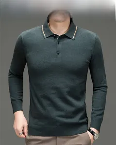 Detailansicht eines dunkelgrünen Poloshirts mit Goldstreifenkragen und Knopfverschluss