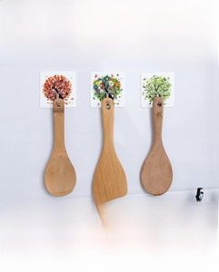 Detail of self-adhesive hooks with Four Seasons tree designs hanging a wooden spatula