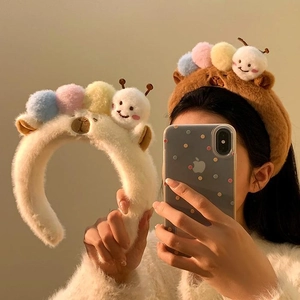 Plush caterpillar headband for women featuring colorful pom-poms in white and brown