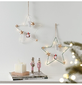 Hanging metal star Christmas light with LED glow and miniature Santa figures in warm setting